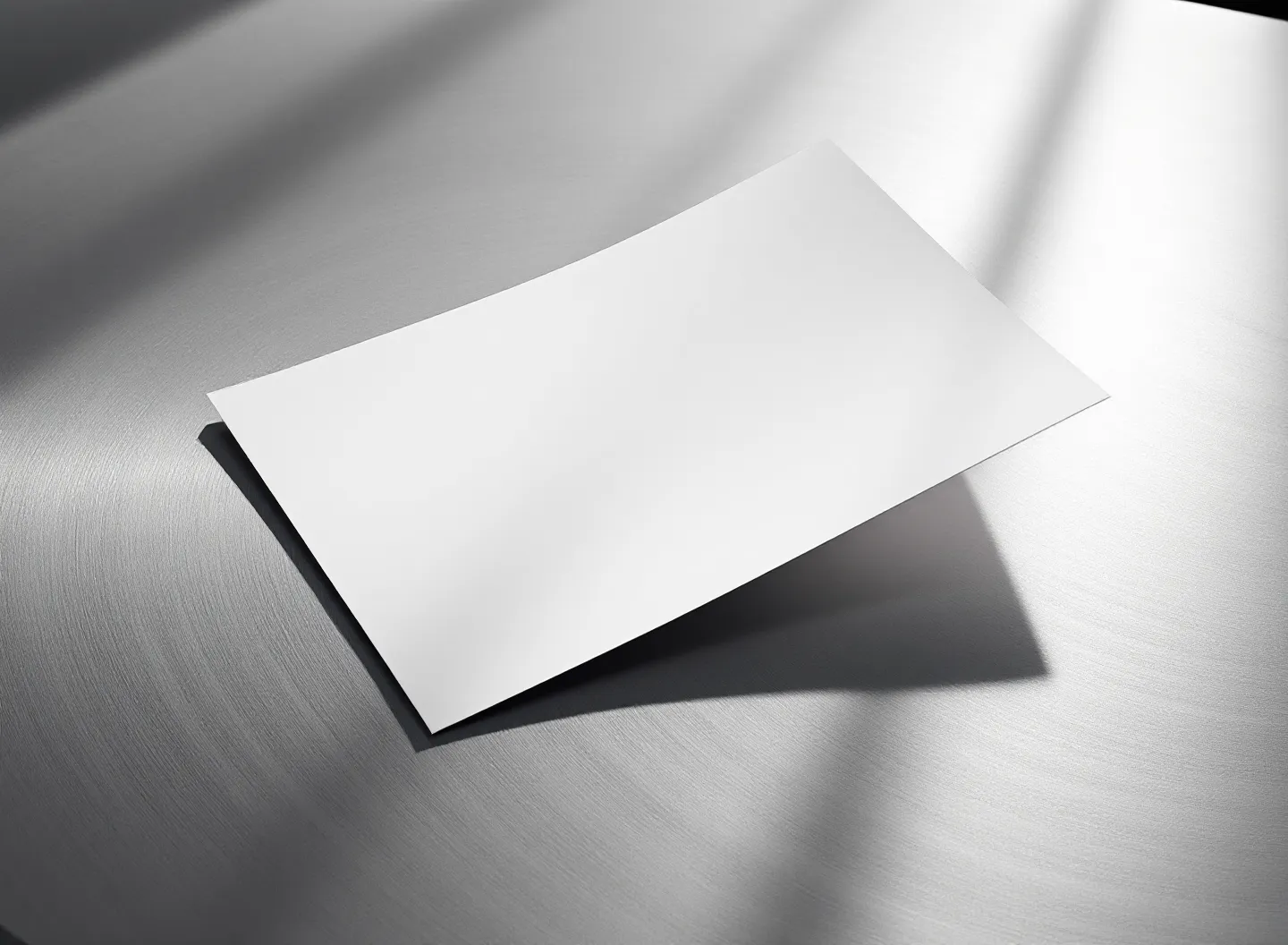 Editorial plate: a single blank document on a brushed-steel surface in cinematic cool light